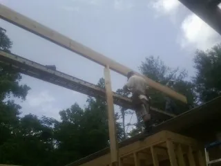 Carpenter setting a ridge beam over a new addition frame — Ice Dam Removal by Roofing Brothers in Campbell Hall