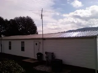 New metal roof on a single wide mobile home with a TV antenna in Campbell Hall
