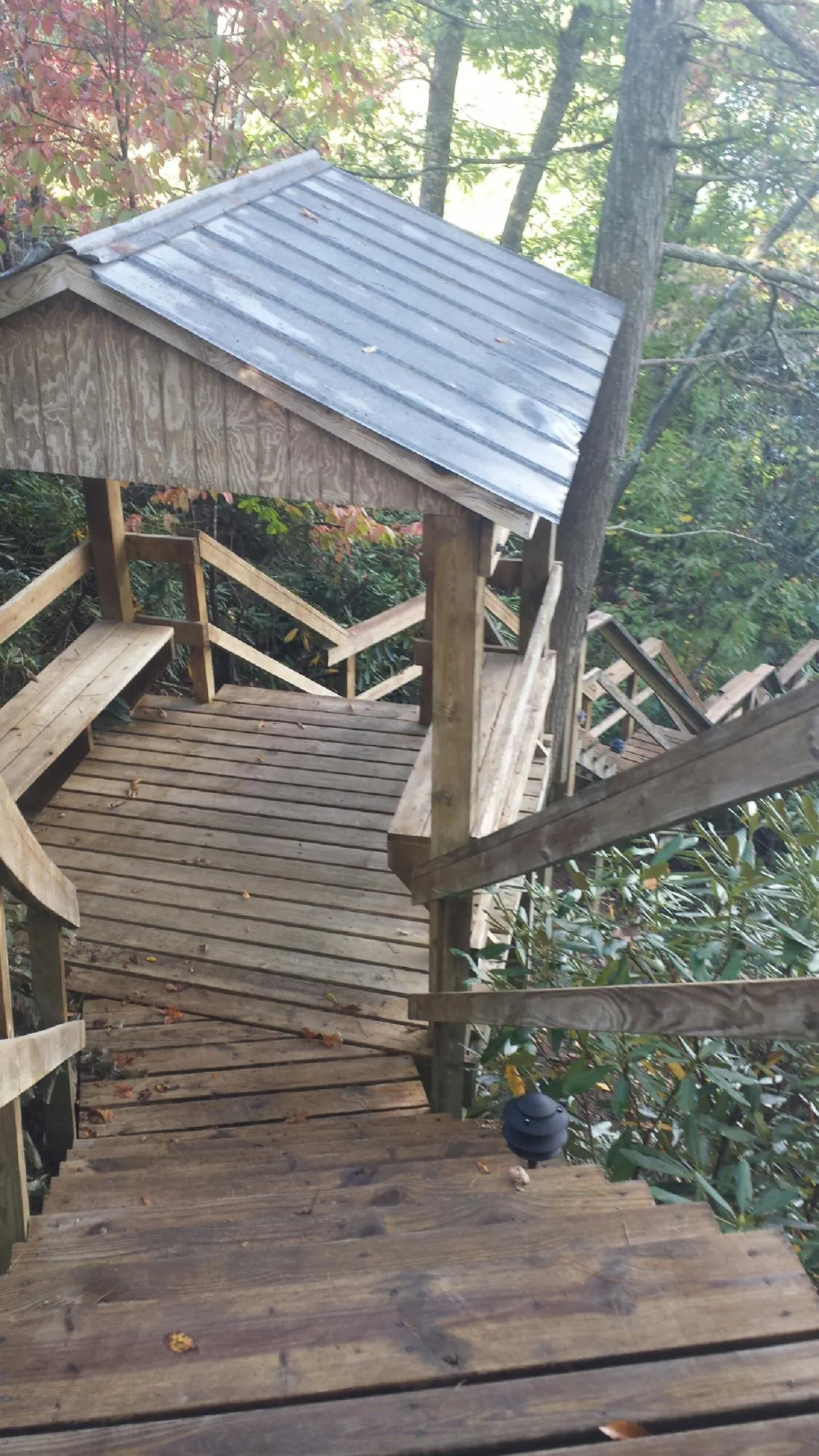 Metal roofed shelter over wooden steps on a wooded walkway — Skylight Repair & Installation work by our crew in Campbell Hall
