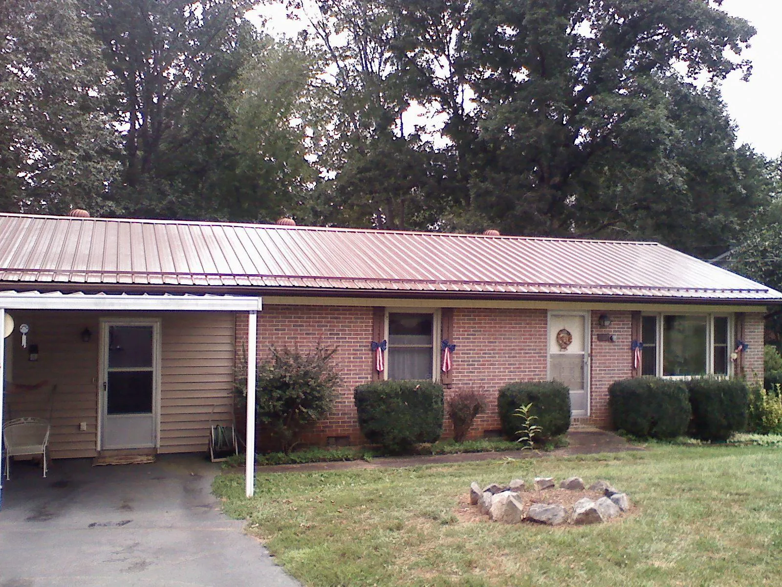 Bronze metal roof and carport on a brick ranch home — Roof Repair work by our crew in Campbell Hall
